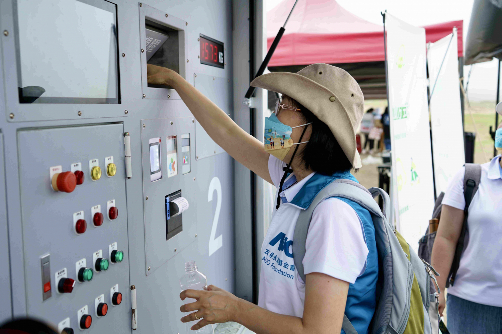 志工們將拾起的寶特瓶投入「好歸塑專車」，讓廢棄塑料空瓶可以直接粉碎、縮小體積，未來(lái)將可再製成購(gòu)物袋、寶特衣、悠遊卡等生活用品